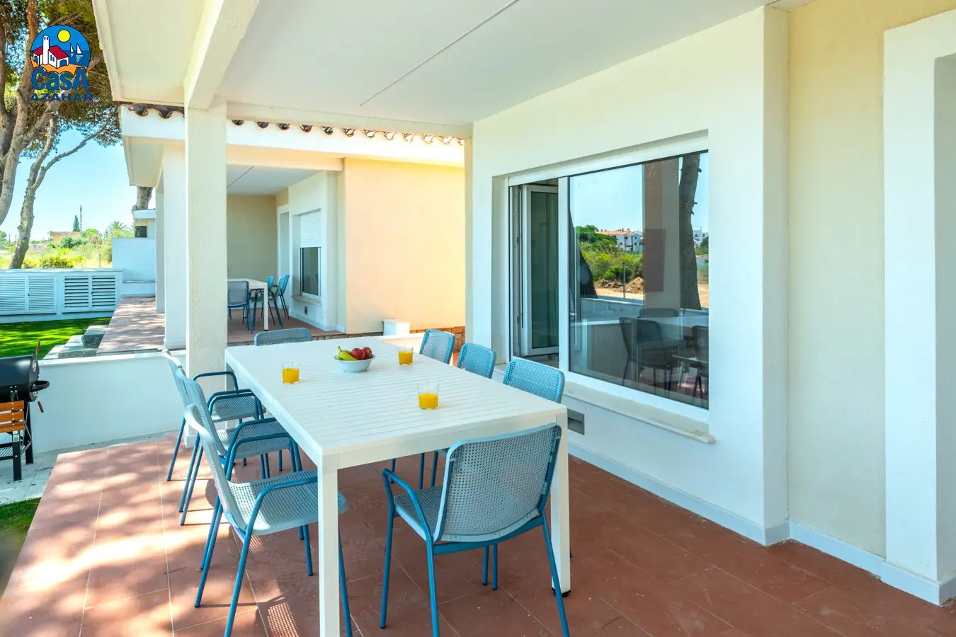 Terrasse couverte avec table et jardin gazonné dans l'une des Villas Sunset d'Alcossebre